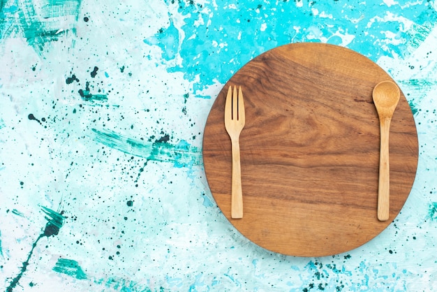 Free Photo top view wooden cutlery forks and spoon on the light-blue background spoon wood light color