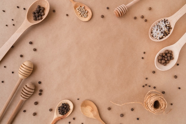 Top view of wooden spoons with condiments and copy space