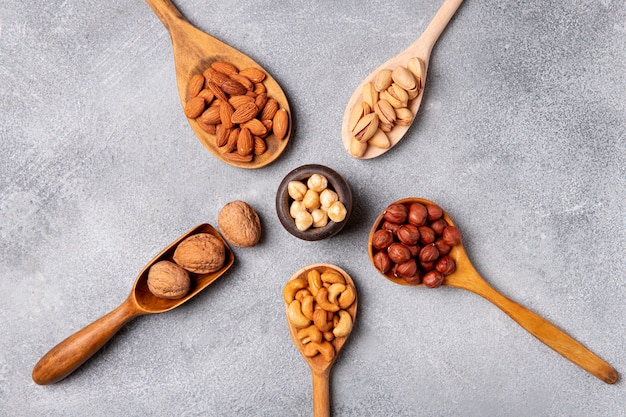 Free photo top view wooden spoons with nuts