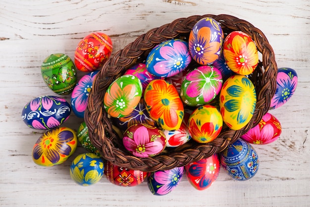 Free photo top view of wooden surface with basket and easter eggs