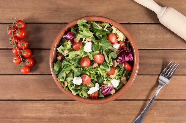 Free photo top view of wooden surface with delicious salad