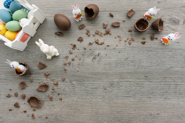 Top view of wooden surface with easter eggs and rabbits