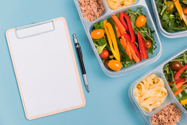 Top view work lunchboxes with blank notebook