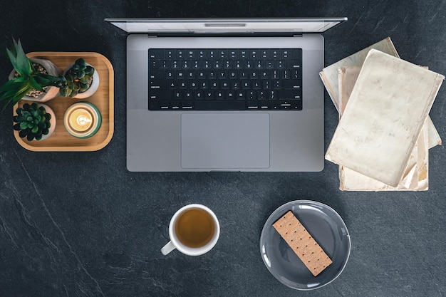 Free photo top view of a workplace with a laptop books and tea