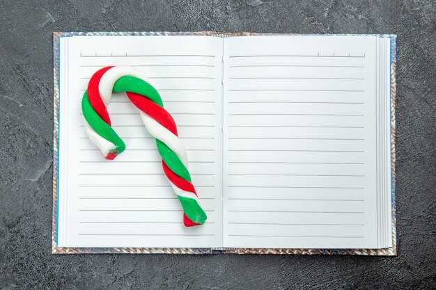 Top view a xmas candy on opened notebook on dark background