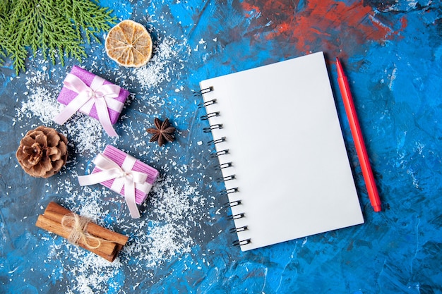 Top view xmas gifts fir tree branches cones anises on blue surface