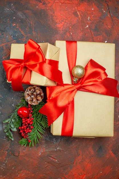 Free photo top view xmas gifts xmas tree branch on dark red table