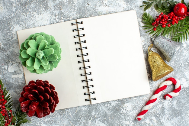 Top view xmas pinecones on notepad xmas tree ornaments on grey white table