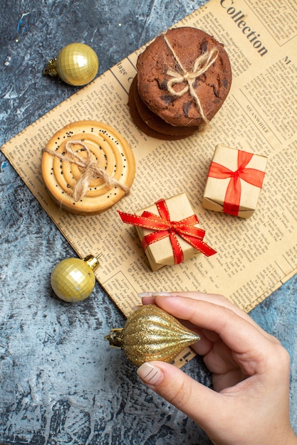 Top view xmas present with biscuits and toys on light-dark background