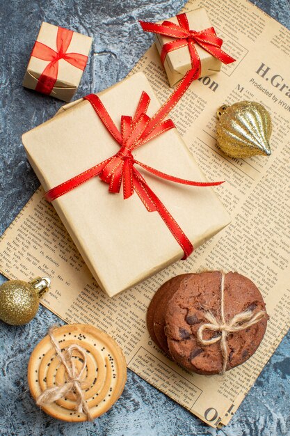 Top view xmas presents with biscuits and toys on light-dark background