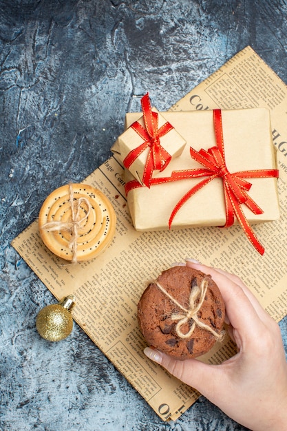 Top view xmas presents with biscuits and toys on light-dark background