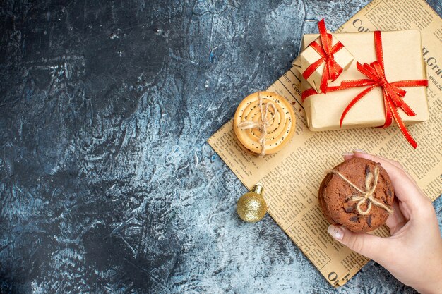 Top view xmas presents with biscuits and toys on light-dark background