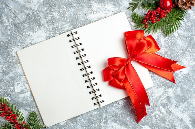 Top view xmas red berry bow red on notepad on grey white table