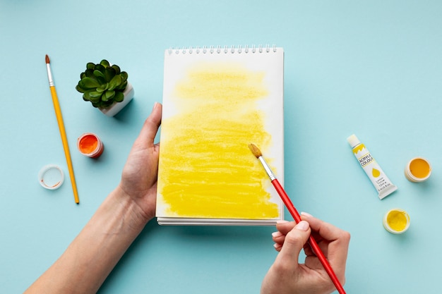 Top view of yellow aquarelle on notebook