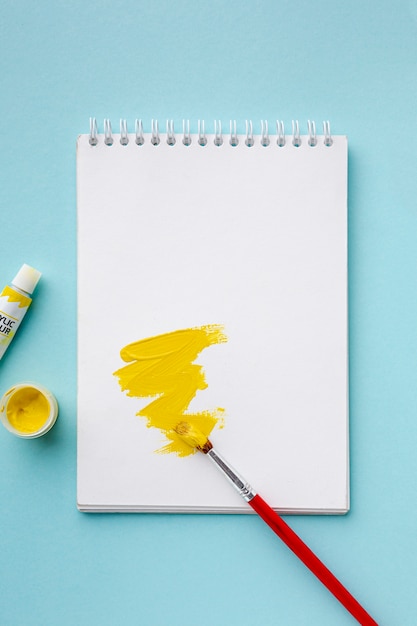 Free photo top view of yellow aquarelle on notebook