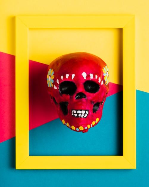 Free photo top view yellow frame with red skull