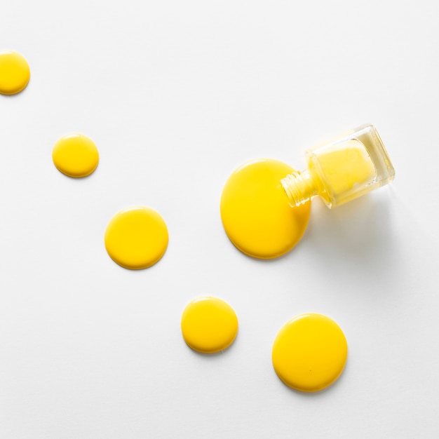 Top view of yellow nail polish on white background