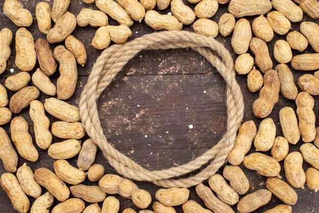 Top view yellow nuts with rope on brown, nut walnut snack salt