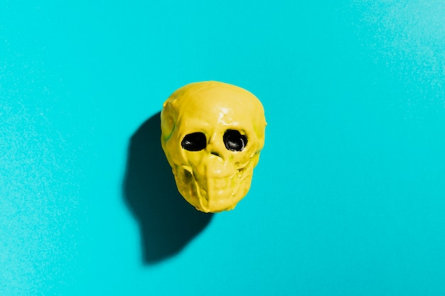 Free photo top view yellow skull on blue background