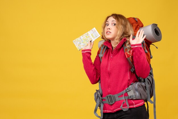 Top view of young scared travelling girl in medical mask collecting her luggage and holding map