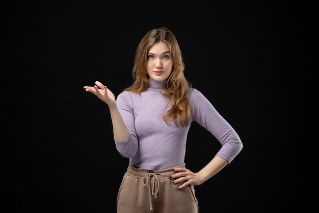 Top view of young thoughtful girl pointing something on the right side on dark