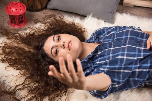 Top view of young woman lying down on carpet