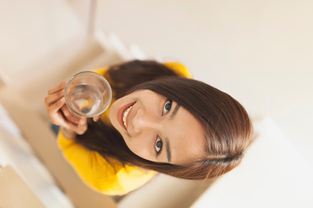 Top view of young woman with glass of water