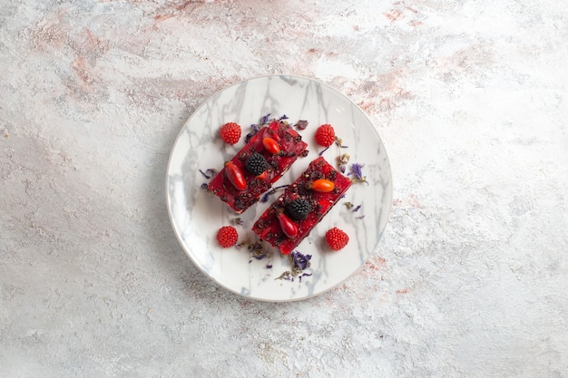 Top view yummy berry cake slices with red cream on white background