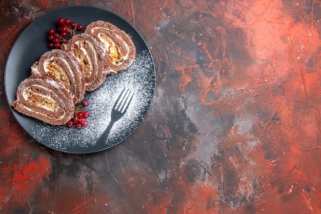 Top view yummy biscuit rolls inside plate on dark floor