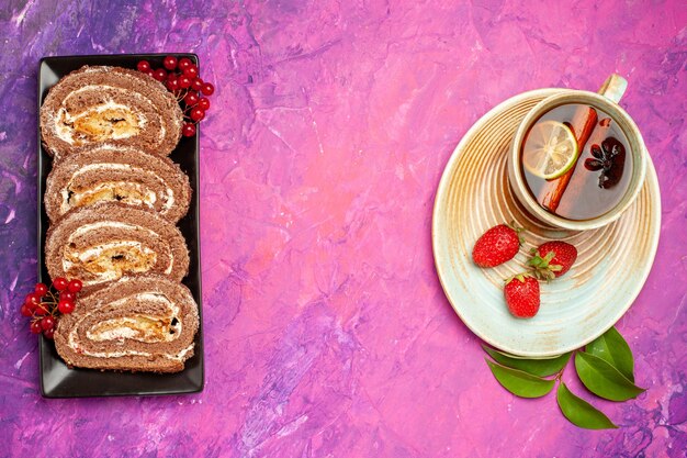 Free Photo top view yummy biscuit rolls with cup of tea on pink desk