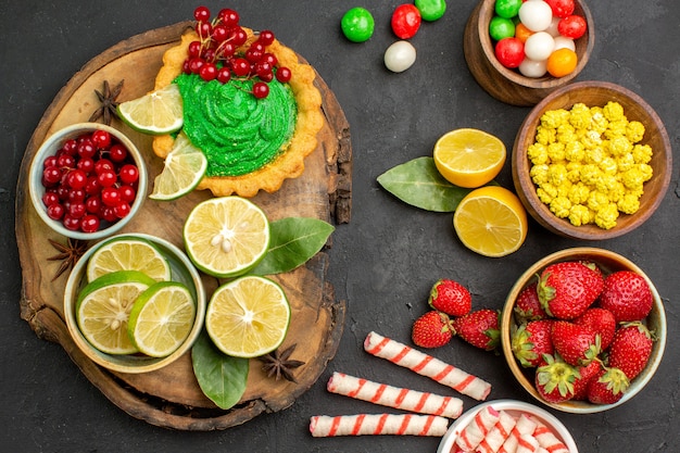 Free photo top view yummy cake with candies and fruits on dark background cookie biscuit sweet