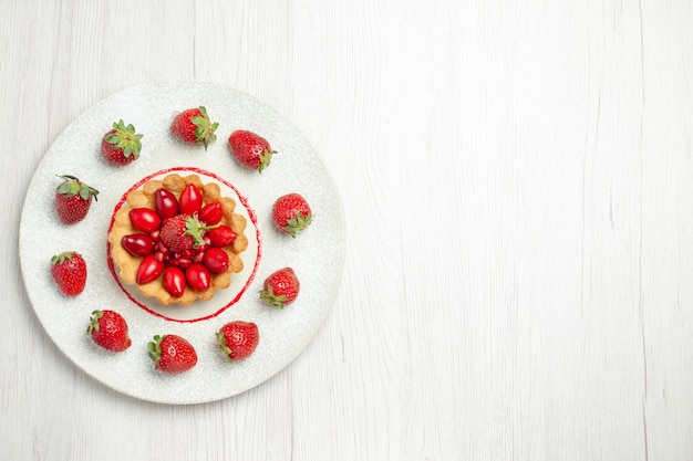 Top view yummy cake with fruits inside plate on the white desk