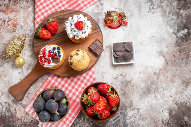 Top view yummy cakes with fresh fruits on light background