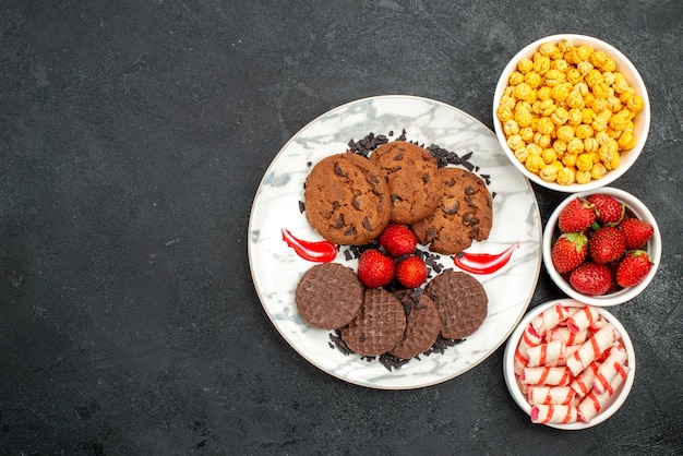 Top view yummy choco biscuits with candies on dark background sugar cake sweet cookie