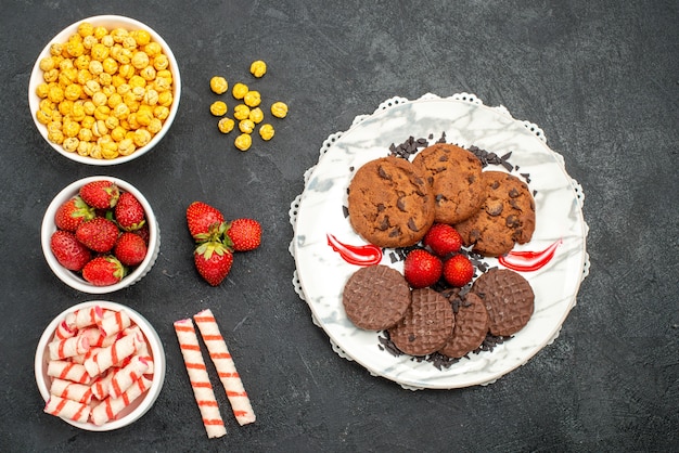 Top view yummy choco biscuits with candies on dark background sweet sugar cake cookie