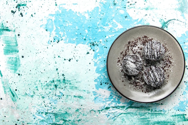 Free photo top view yummy chocolate balls chocolate cakes round formed with icing on blue desk