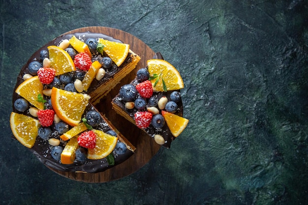 Free photo top view yummy chocolate cake with fruits on dark