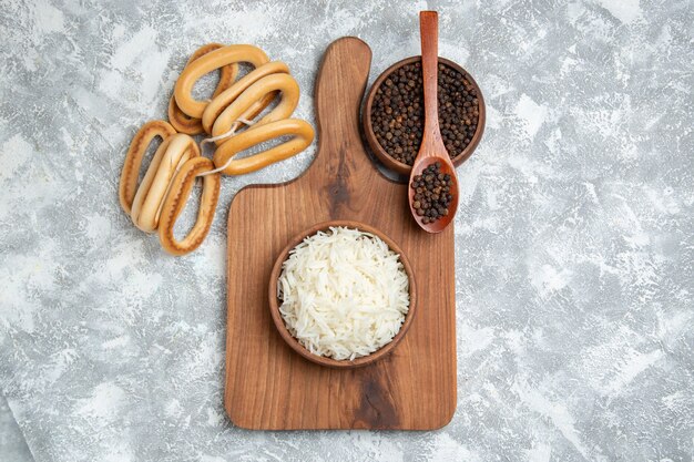 Top view yummy cooked rice with seasoning and sweet crackers on white