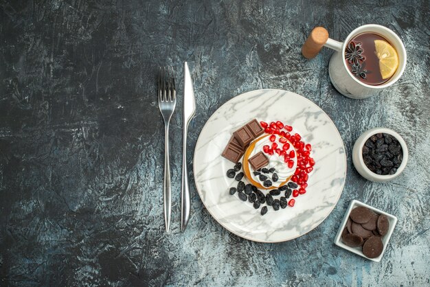 Top view yummy creamy cake with cup of tea on light-dark background