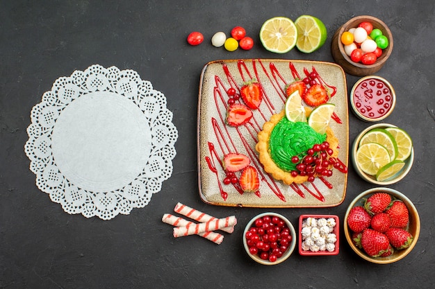 Top view yummy creamy cake with fruits on a dark background biscuit dessert sweet color