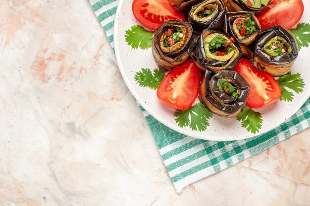 Free Photo top view yummy eggplant rolls with tomatoes and greens