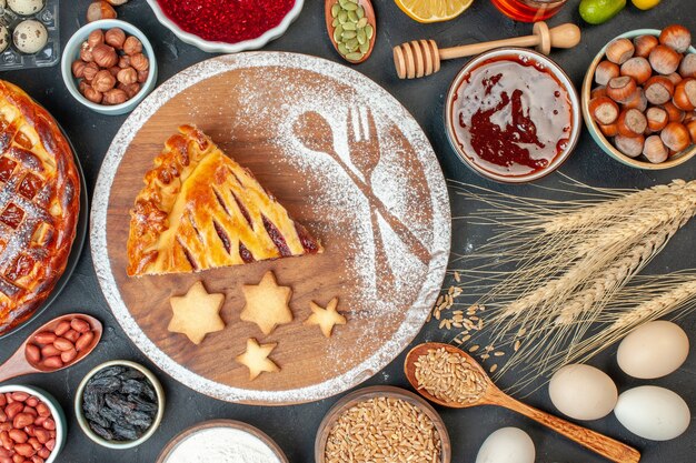 Top view yummy fruit pie with jam nuts and flour on a dark biscuit dessert pie tea cake dough sweet bake sugar