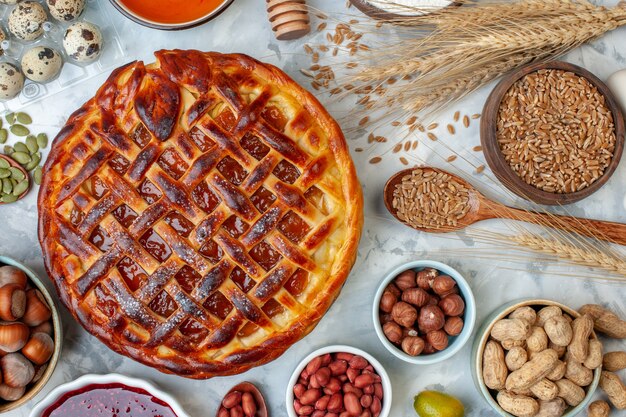 Top view yummy fruity pie with nuts and eggs on light bake biscuit pie dessert cake cookie bakery bun color