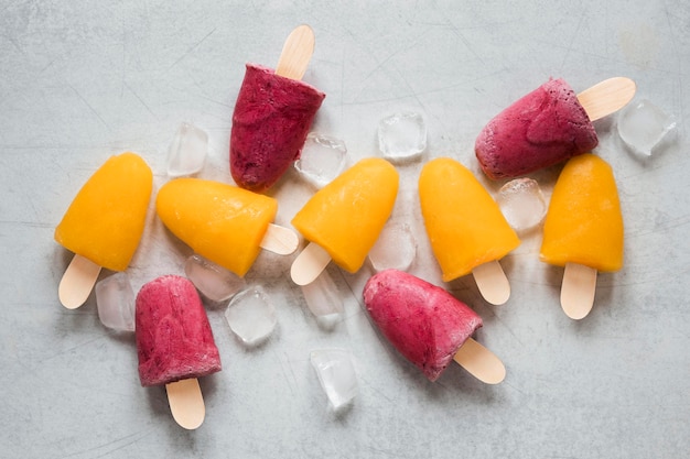 Free Photo top view of yummy fruity popsicles with ice