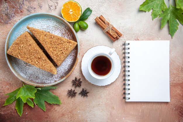 Top view yummy honey cake with tea on light desk sugar biscuit sweet cake