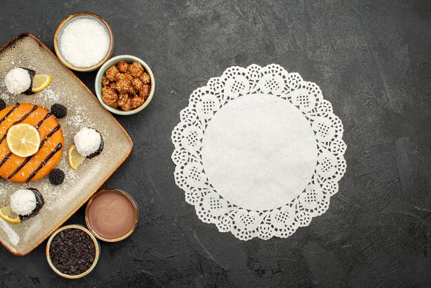 Top view yummy little pie with coconut candies on dark-grey surface cake tea biscuit cookie sweet