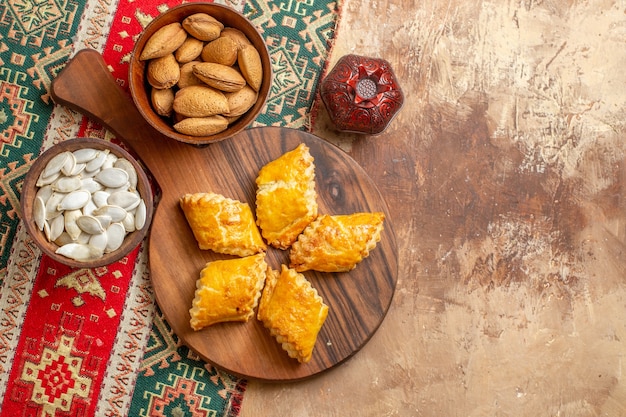 Top view of yummy nut pastries with nuts on brown background