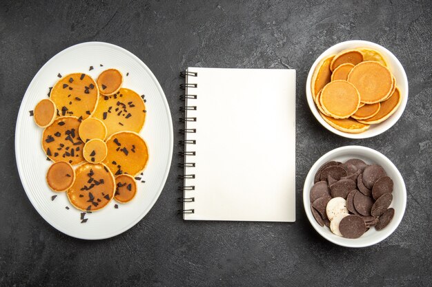 Top view yummy pancakes with choco chips and cookies on a dark background