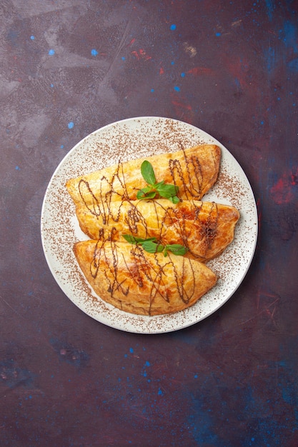 Free photo top view yummy pastries with icing inside plate on a dark background pastry bake sugar biscuit sweet cake