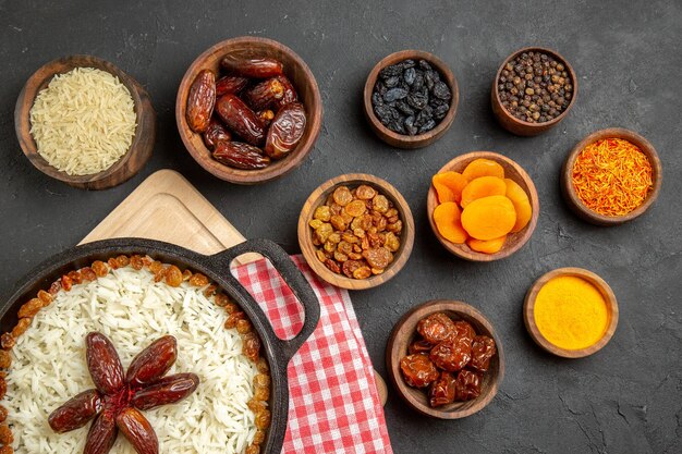 Top view yummy plov cooked rice dish with different raisins on dark floor raisin dish food rice dinner oil